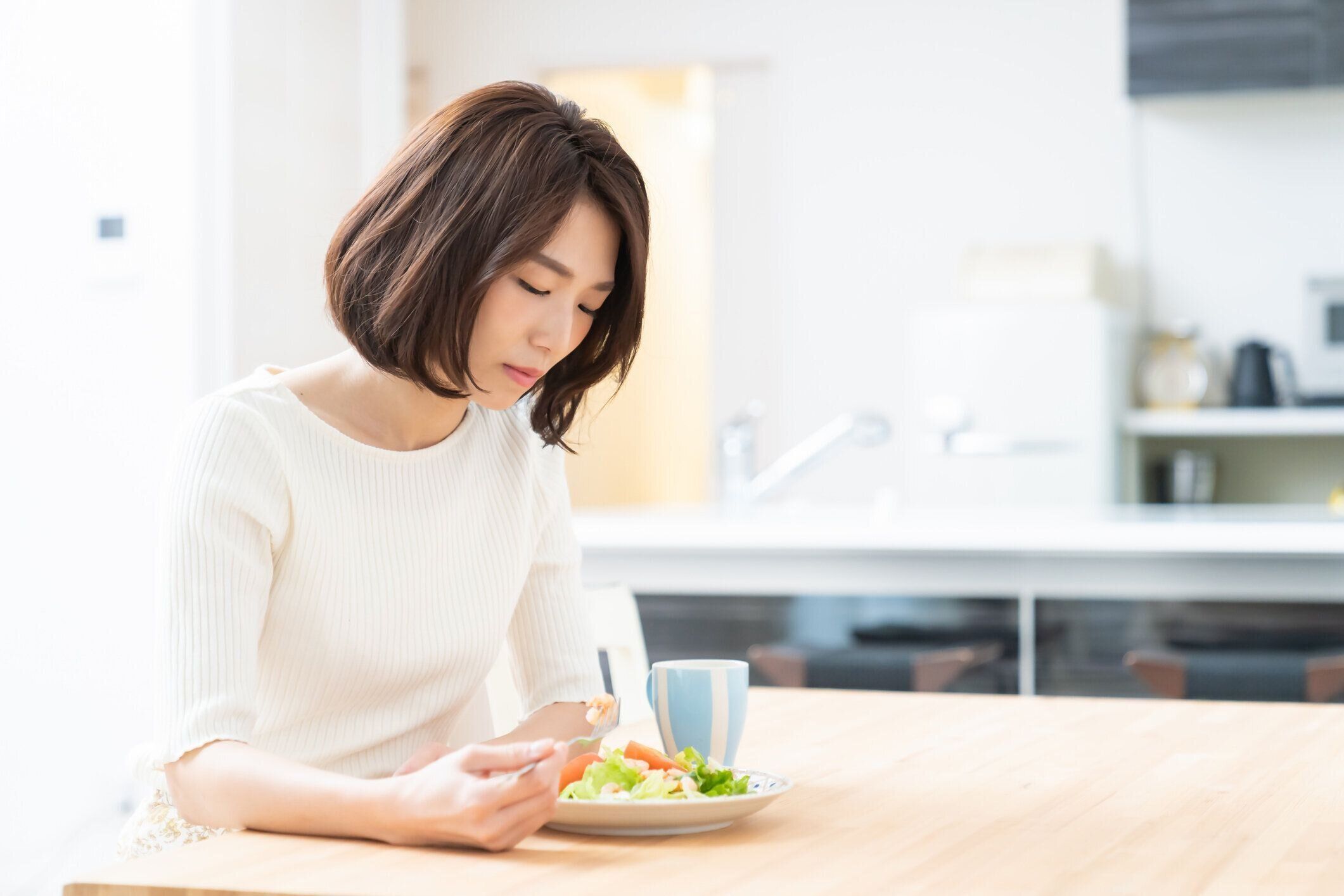 食べる魅力的なアジアの女性、食欲がない
