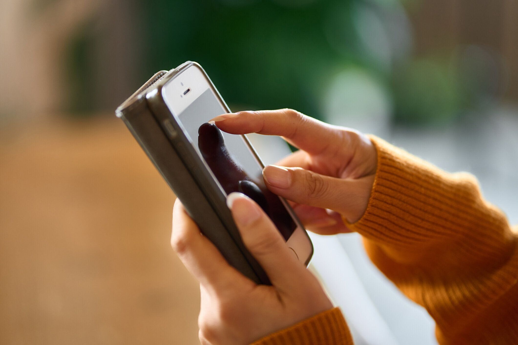 スマホを手に取り、ネットショッピングを楽しむ人