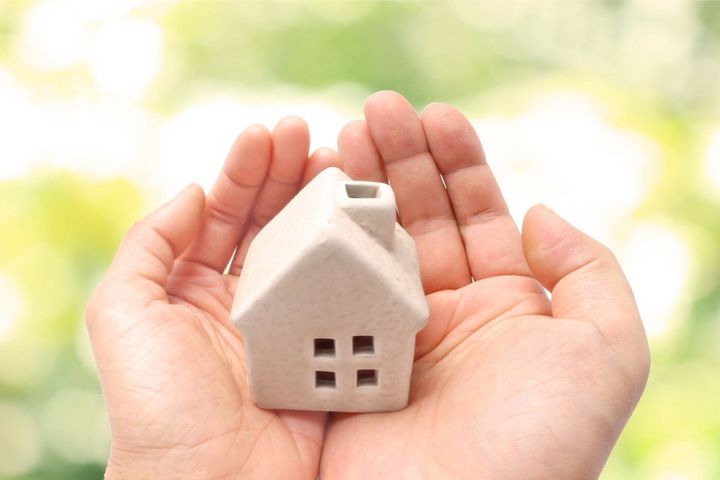 カップルの手のひらにミニチュアの家