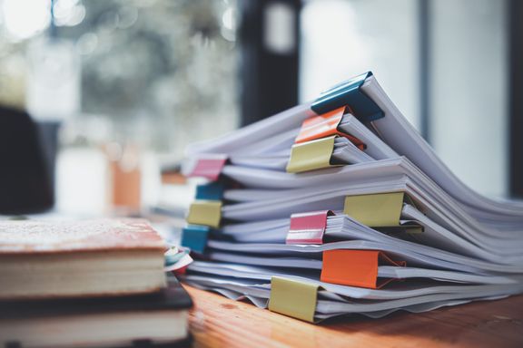 机の上に置かれた書類の山は、ビジネスマンや投資家と会う前に正しい情報を使用するために取締役会に送られる前に検証されるのを待っています。