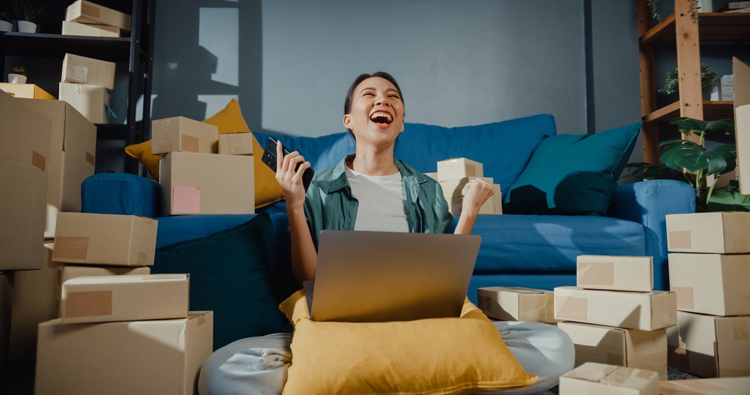 自宅でクライアントに出荷するための小包を準備電話を使用して若いアジアの女性の売り手労働者オンラインストア。