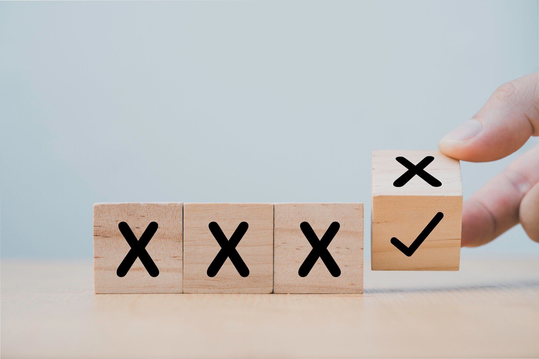 手は正しいマークに誤ったクロスを変更するために木製の立方体ブロックを反転します。