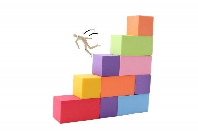積み木の階段から踏み外して落ちそうになる人形