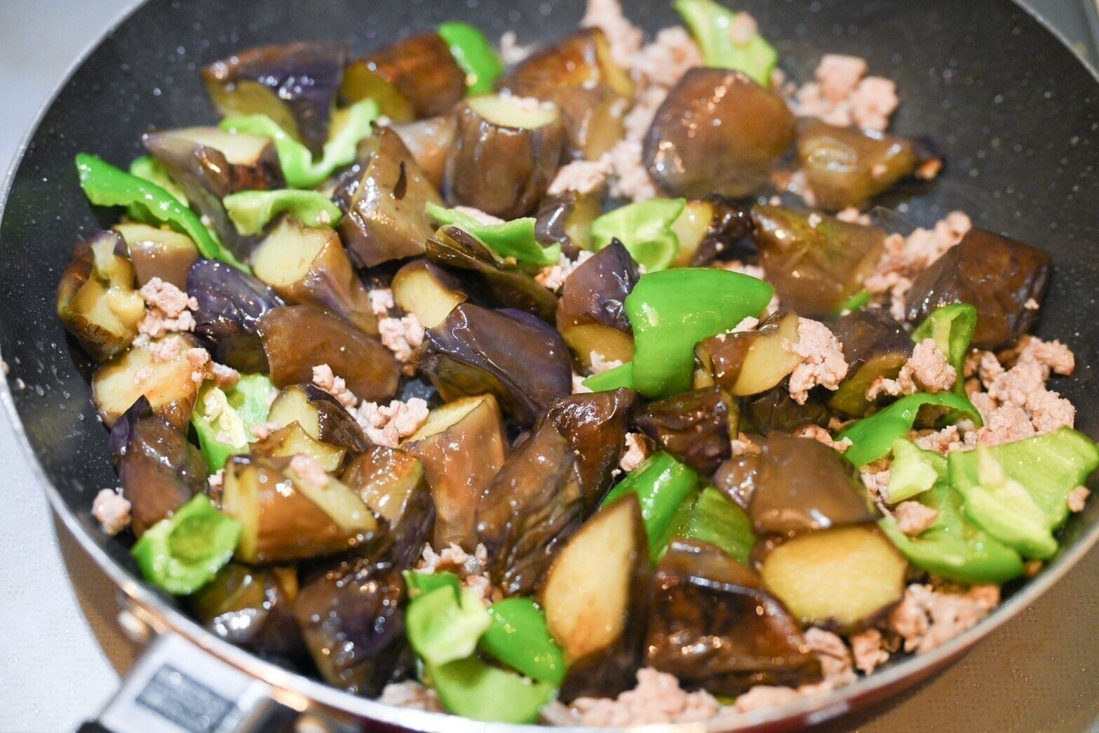 フライパンに入った炒めたなすとピーマン