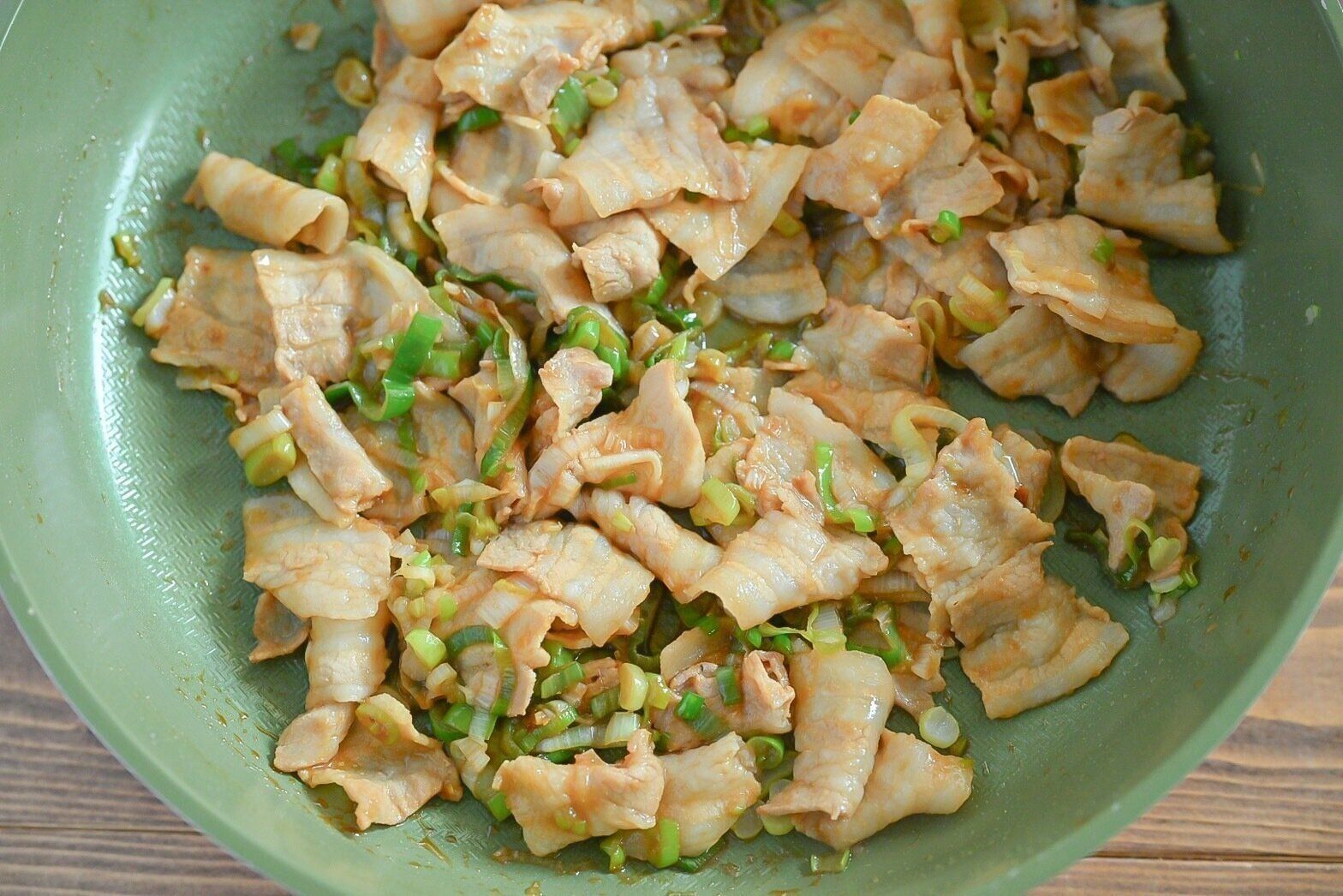 フライパンに入った炒めた豚肉