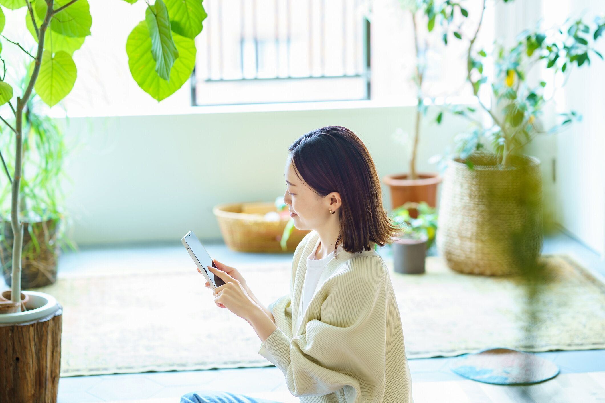 部屋でスマホを持っている女性