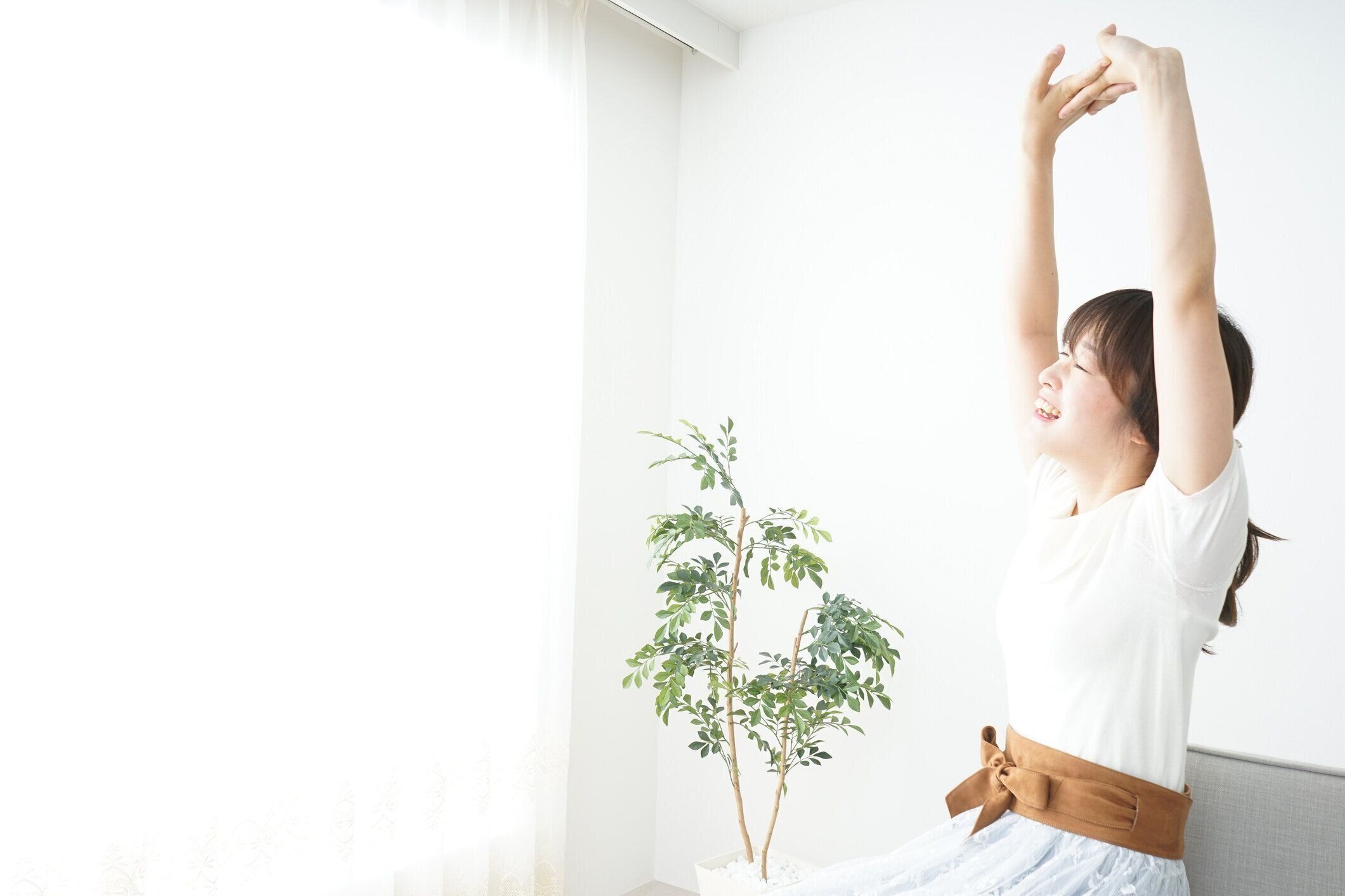 若い女性は彼女の腕のストレッチ