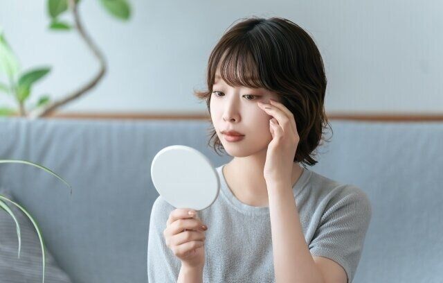 目元を鏡で確認する女性