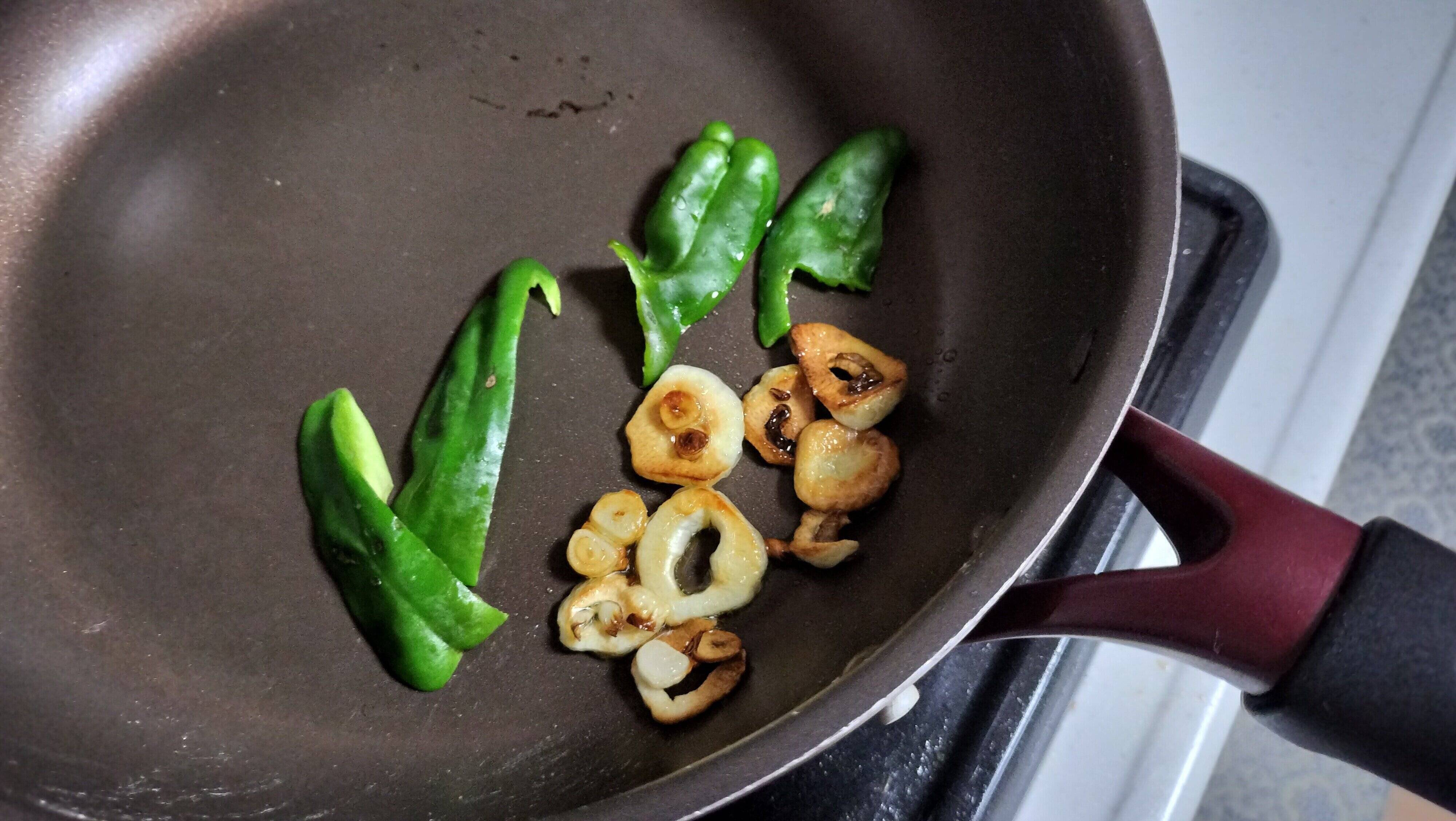 にんにくと付け合せのピーマンを焼く