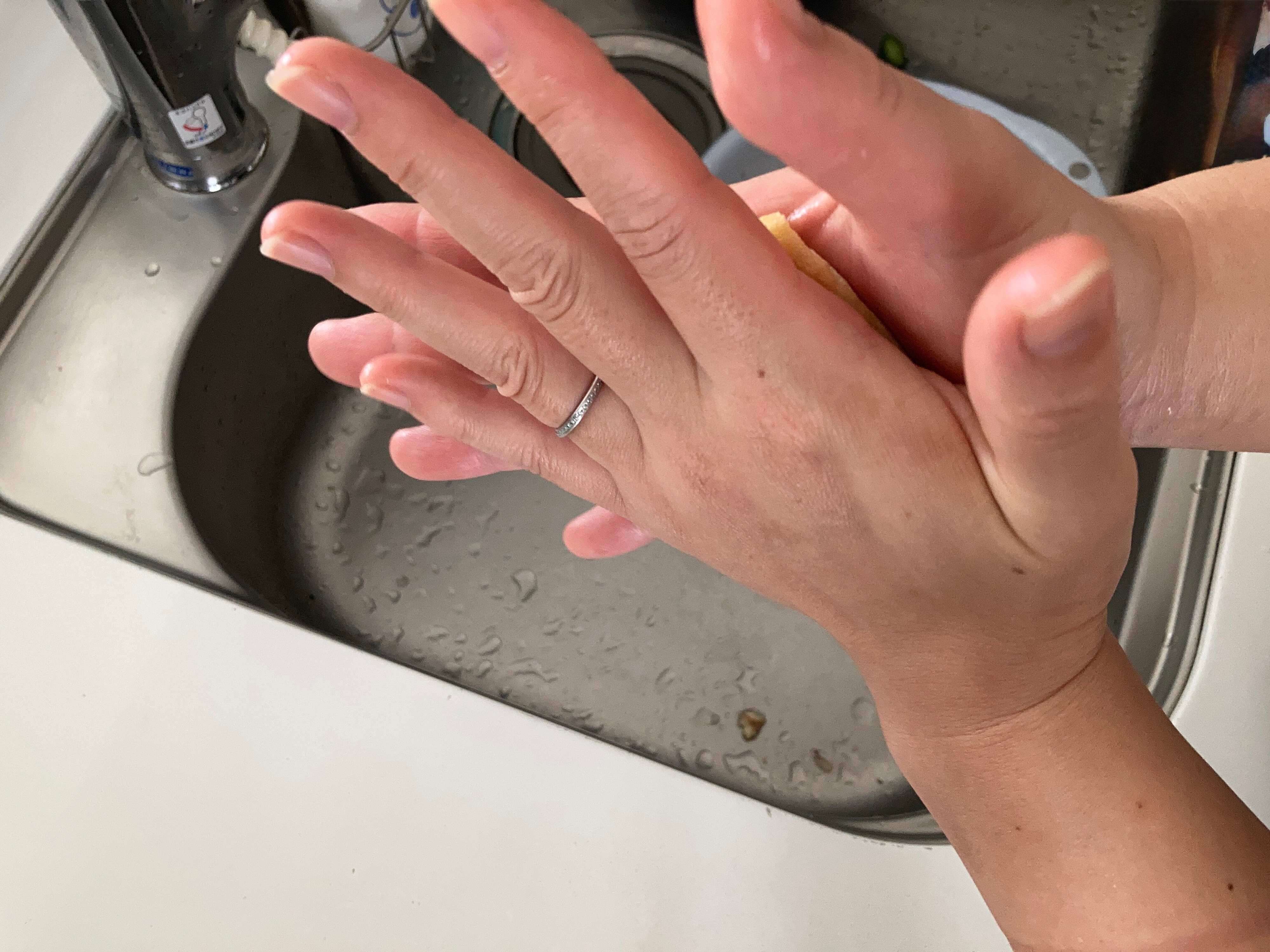 油揚げを手のひらで挟んでいる