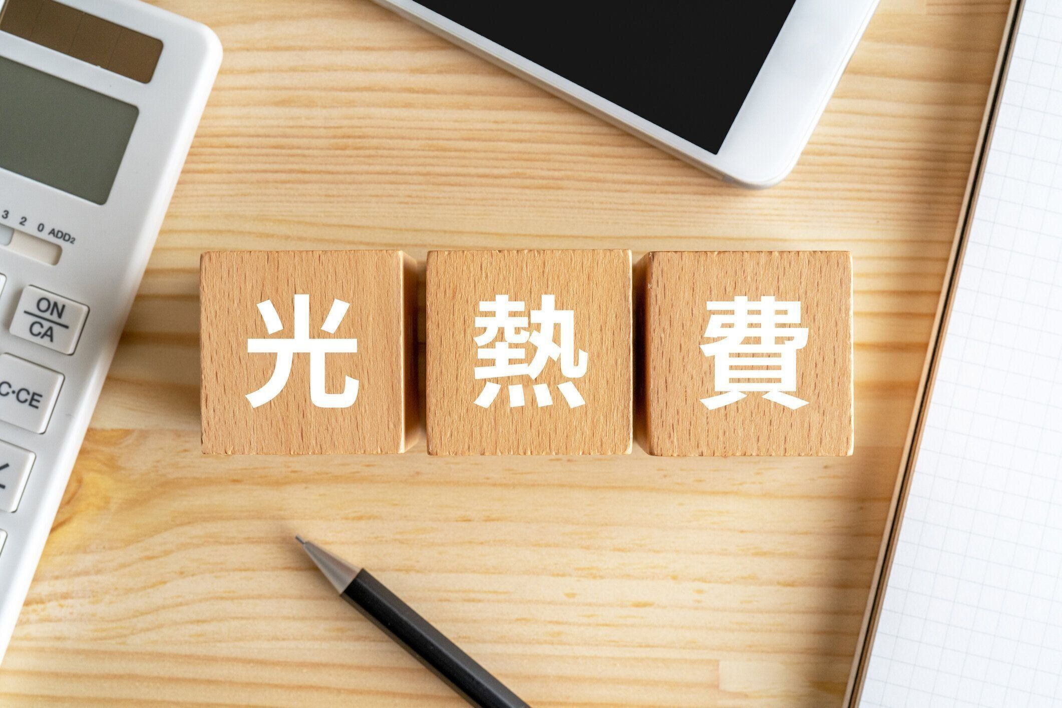 コンセプトの「こねつひ」のテキストが付いた木製のブロック、電卓、スマートフォン。