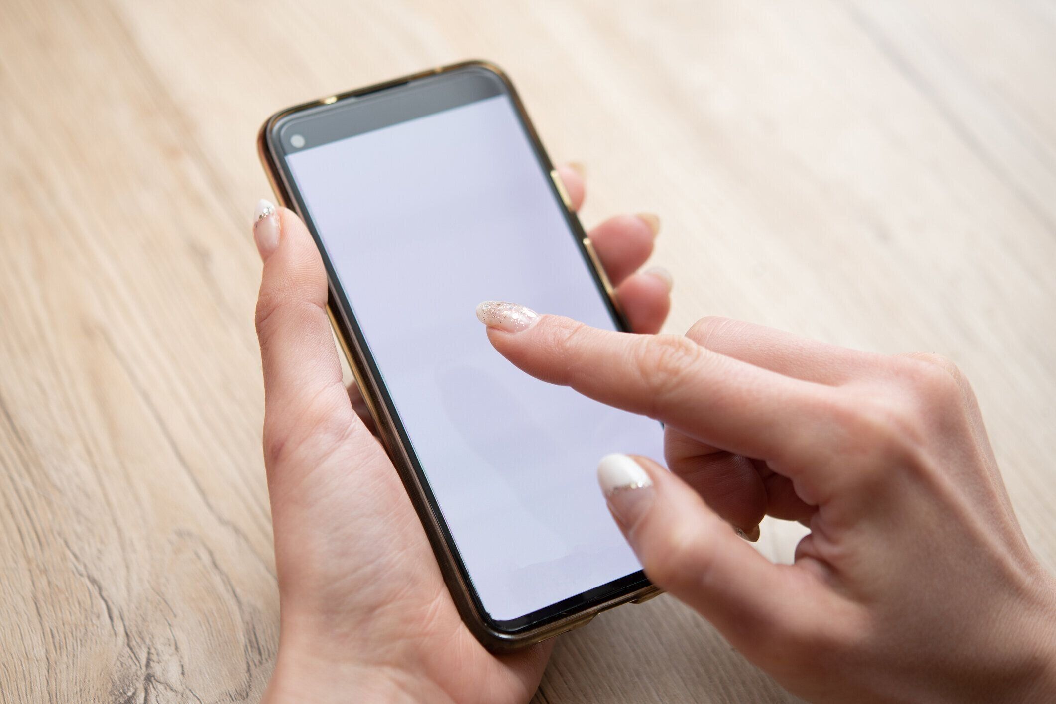 スマートフォンを操作する女性の手