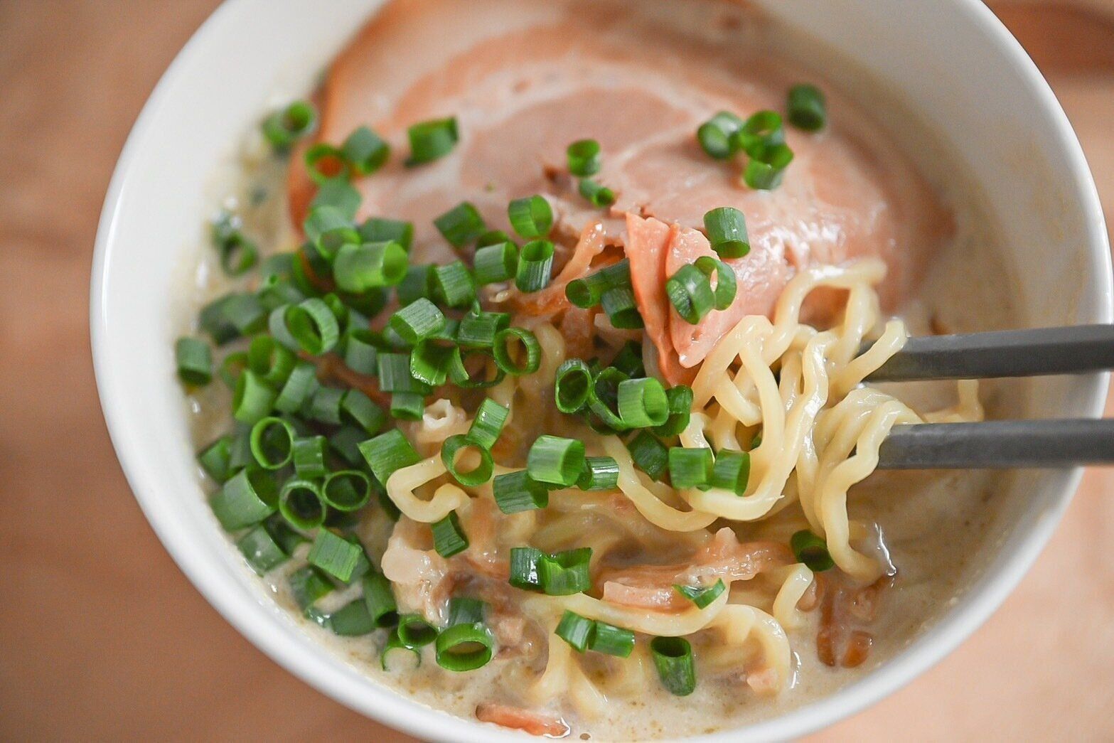 箸で持ち上げたグリーンカレーラーメン