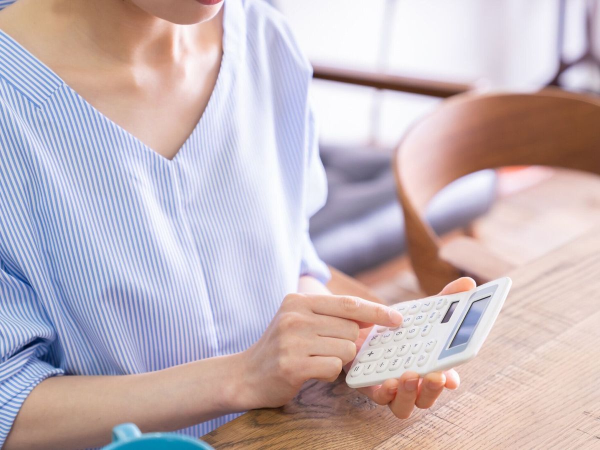 女性の手と電子計算機