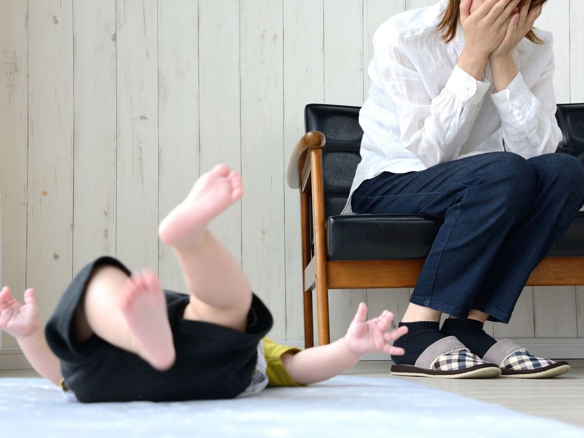 居間で疲れた母親と泣いている赤ちゃん