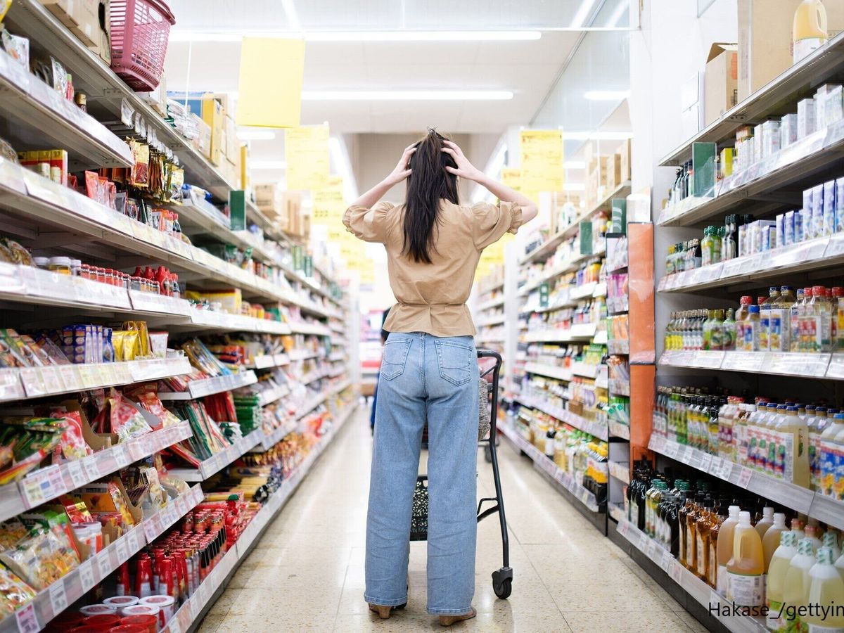 買い物で頭を抱える女性