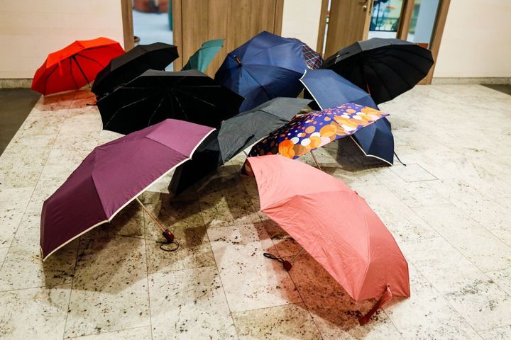 雨の日には、近代的な建物の中で、オフィスの入り口の外で乾燥するために傘が置かれました。