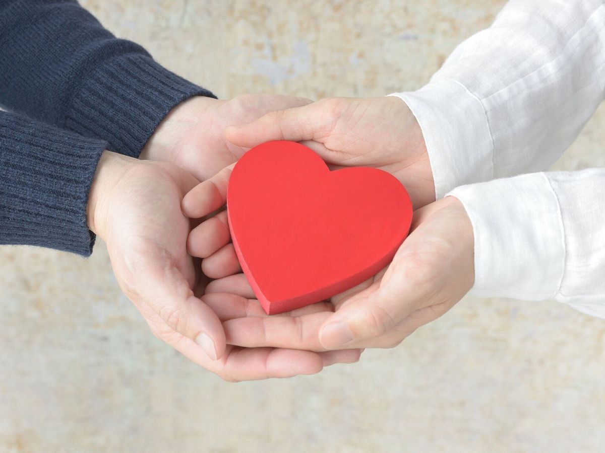 男性と女性の手で覆われた心臓オブジェクト