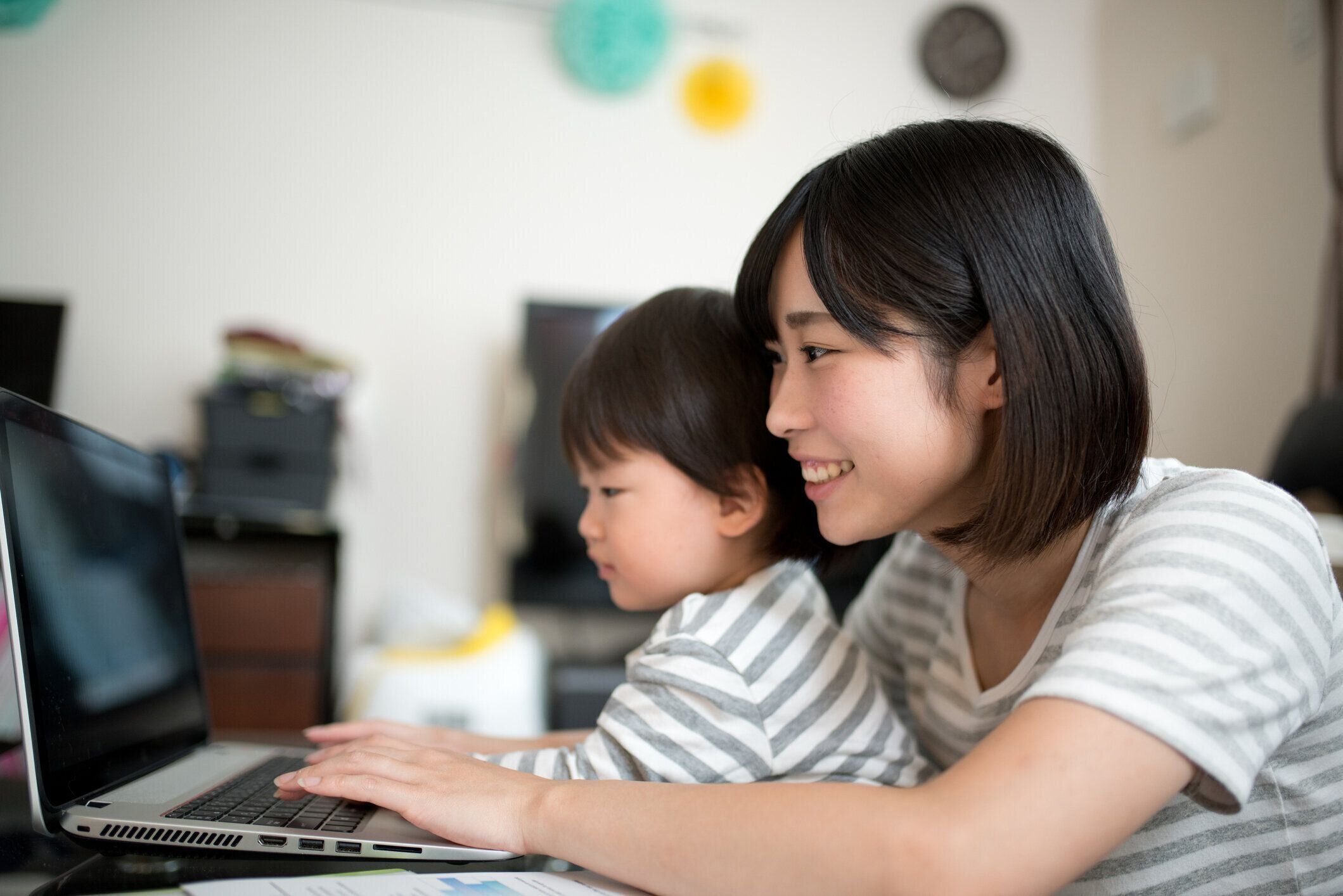 若い母親は彼女の子供と家の中の作業