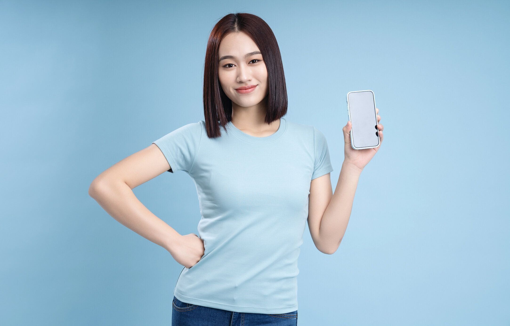 背景にポーズをとるアジアの若い女性の画像