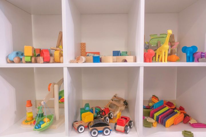 木の子供のおもちゃが入った白い棚。