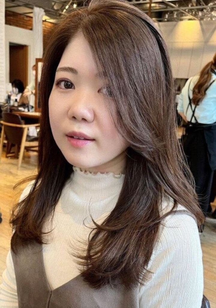 40代丸顔に似合うヘアスタイル。流れる前髪で気になる頬ラインをカバー!