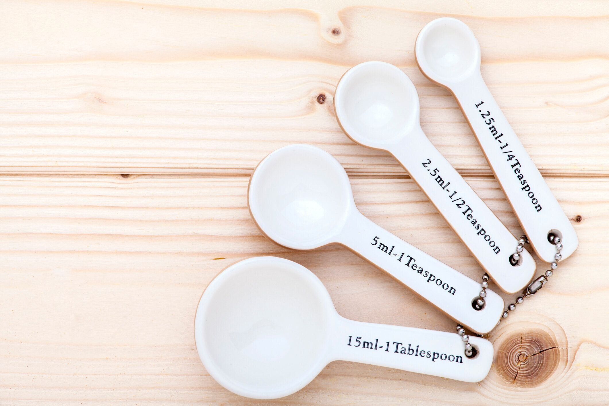 セラミック測定スプーンにパインウッドの背景上から見た。