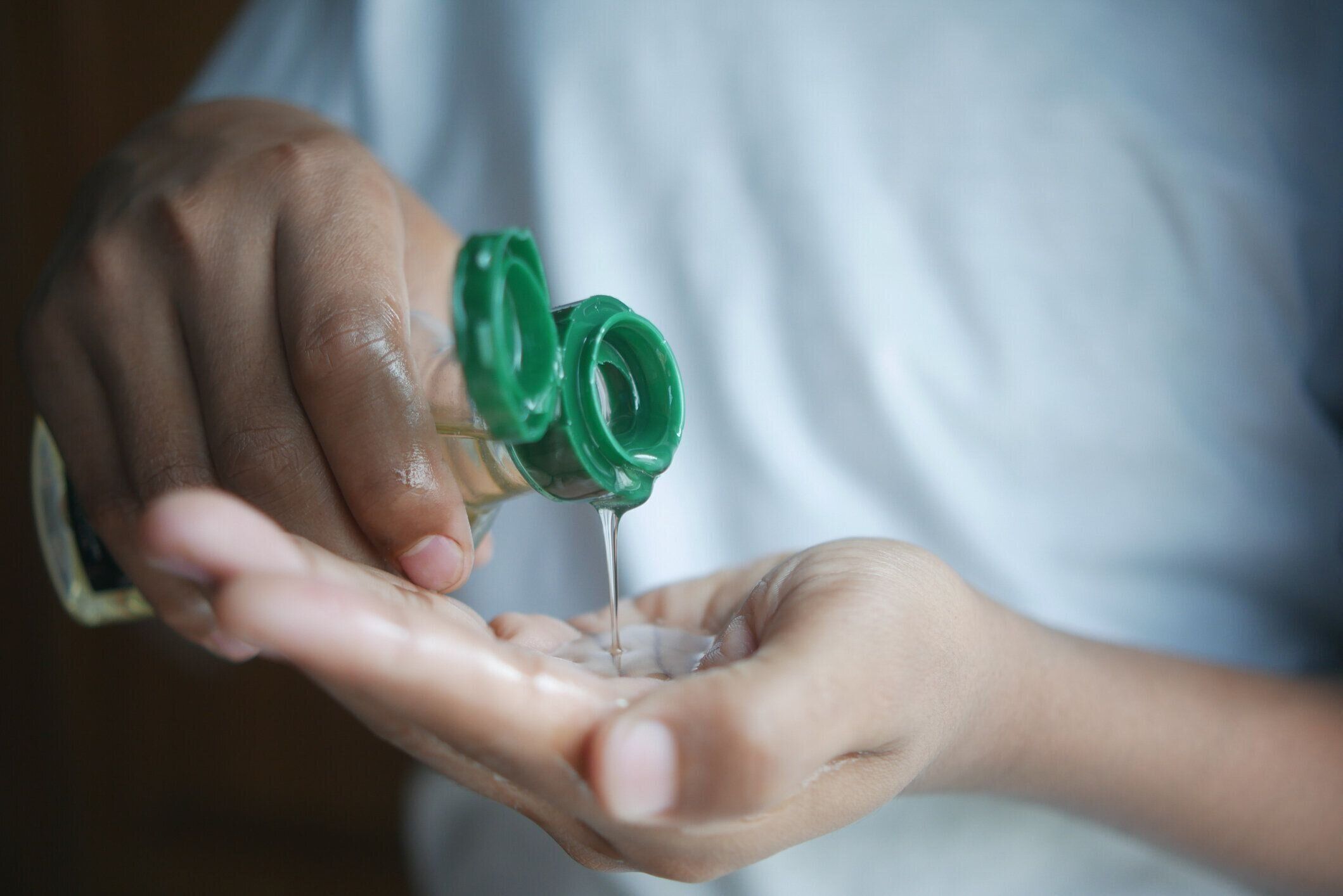 手に髪油を注ぐ若い男