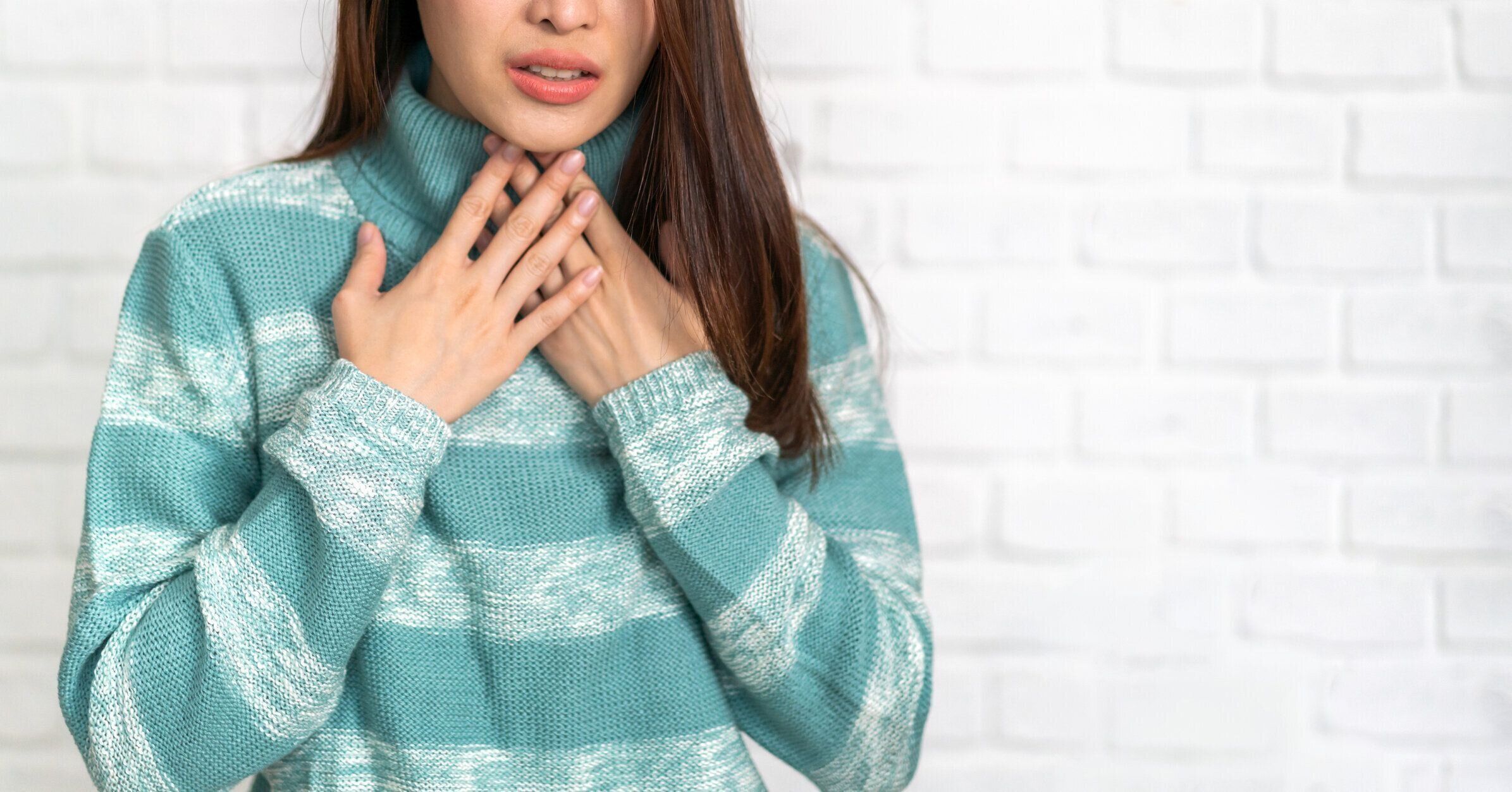 喉を押さえる女性
