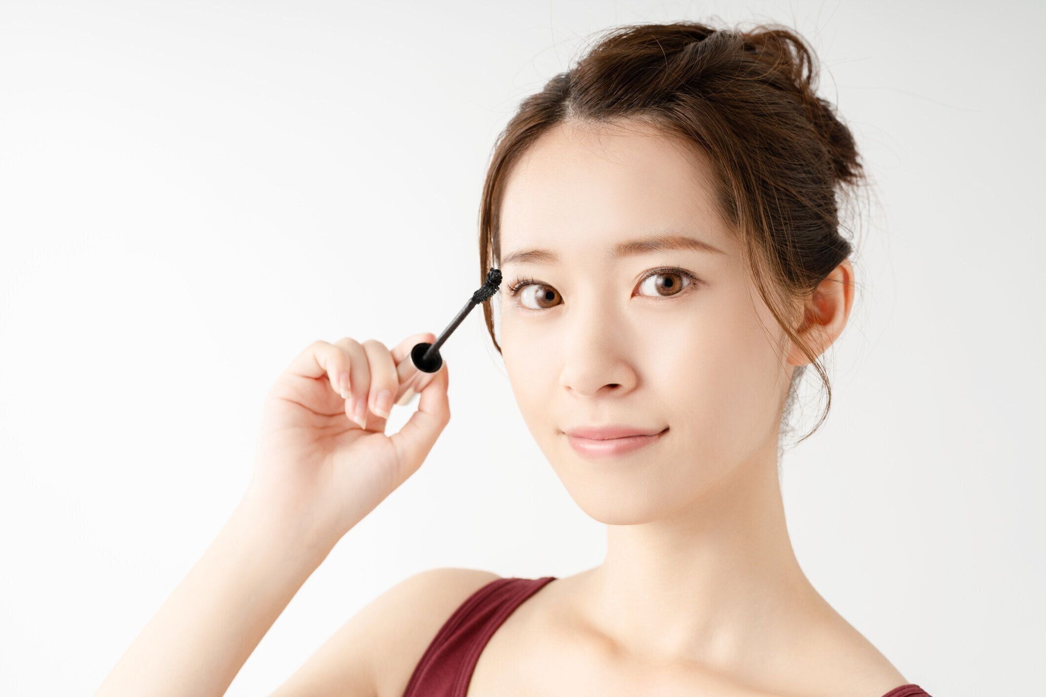 マスカラを適用する若い女の子.