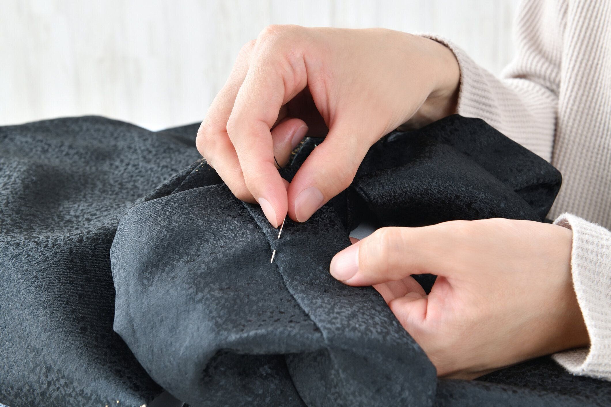 針と糸で縫う女性の手