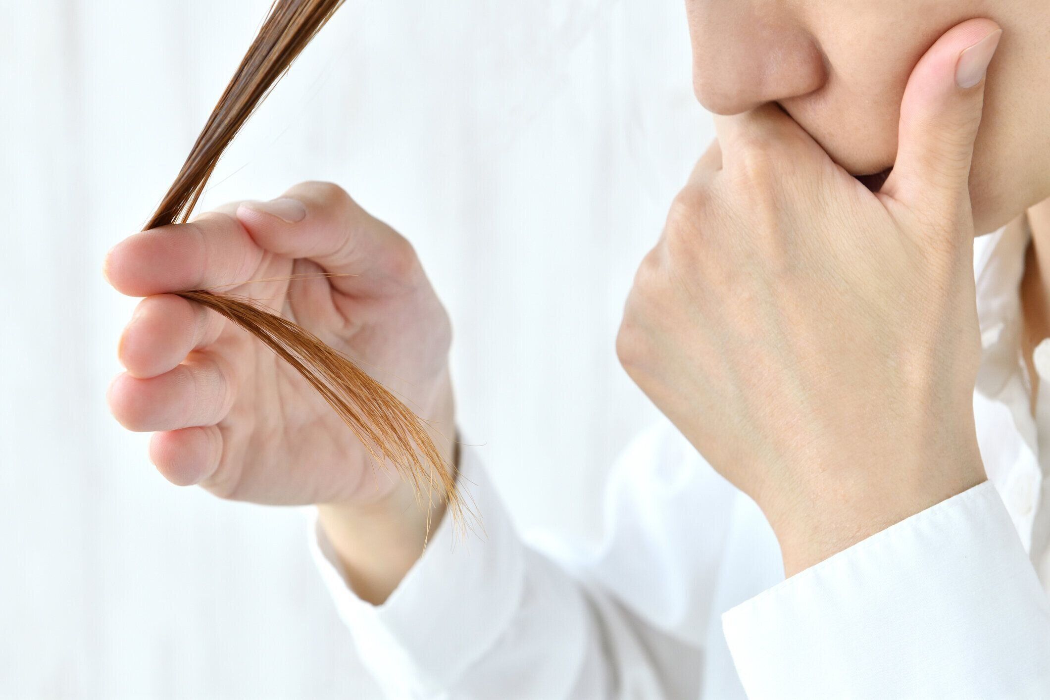 髪の状態をチェックする女性