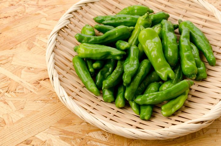 合板ボードの背景に竹のふるいに獅子とピーマン