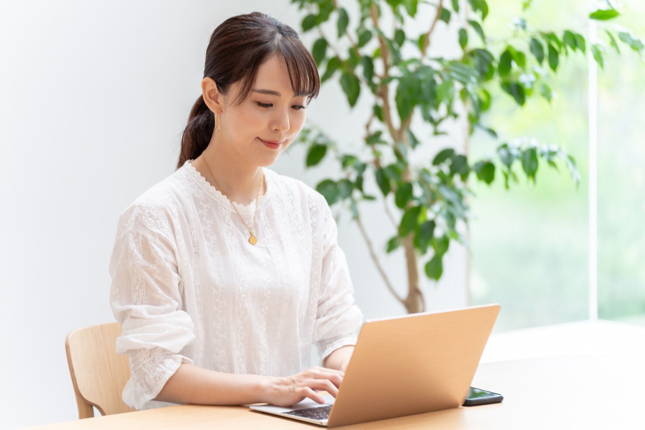 リビングルームでラップトップを使用して魅力的な日本の女性