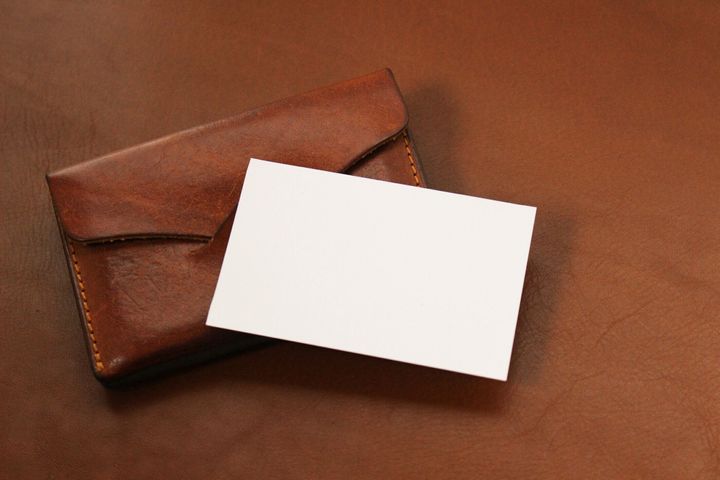 テーブルの上に革のカードケースが付いた空白の名刺