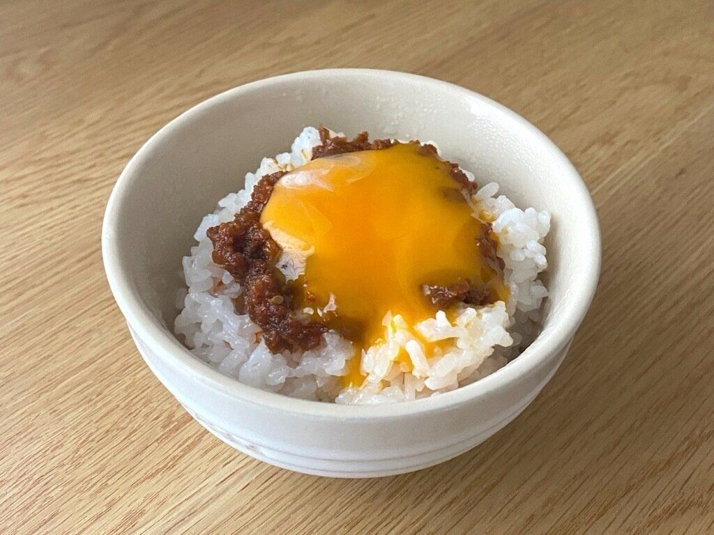 白米の上にのせたご飯で汁なし坦坦と卵黄