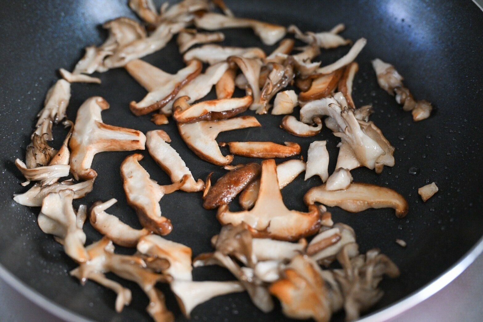 フライパンに入った加熱したきのこ