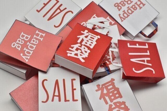 「SALE」と書かれた紙袋がたくさん積み重なった様子