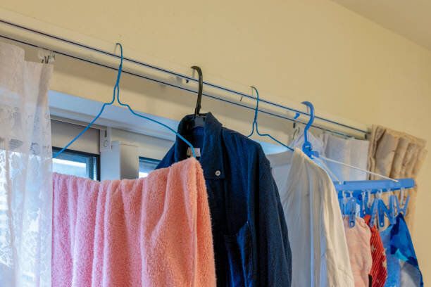 部屋のカーテンレールに洗濯物をぶら下げる
