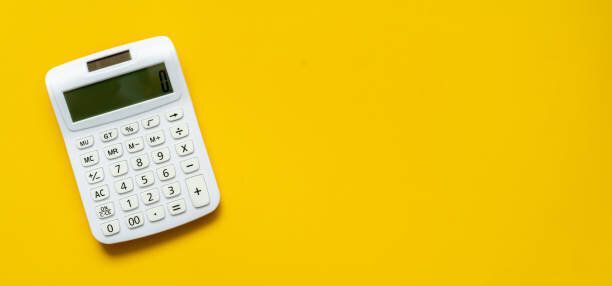 退職後のライフスタイルの概念のための自宅で毎月の費用をカウントし、計画するためのコピースペースと黄色の背景にトップビュー白電卓をクローズアップ