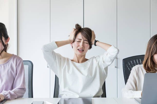 若い女性は彼女の頭を抱えています。
