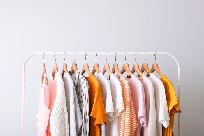 屋内の明るい背景のラックにファッション服。テキストの場所