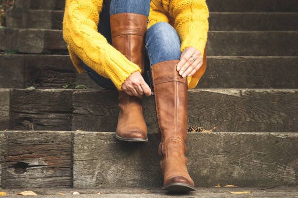 女性は彼女の革のブーツにジッパーを締め付け