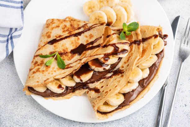 チョコレート、バナナを詰めたクレープまたはブリニ
