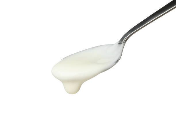 白い背景に分離サワークリームヨーグルトとスプーン