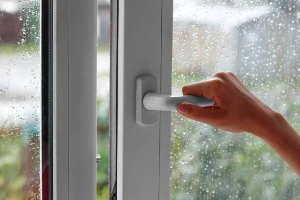 女性の手では、水滴とウィンドウが開きます。ウィンドウを閉じます。雨の日。クローズ アップ