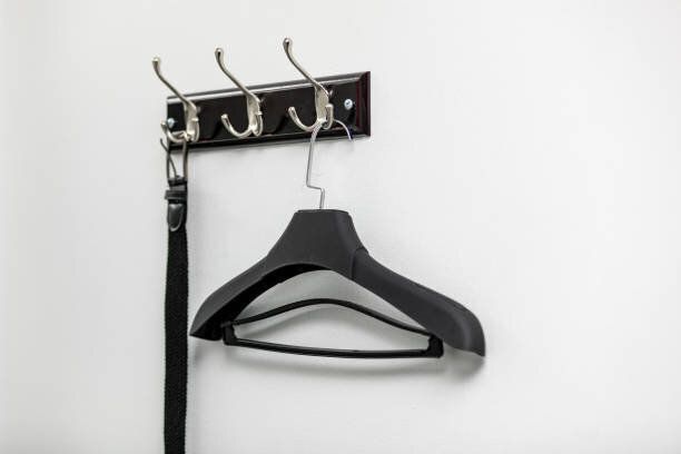 フックにハンガーに男性の革ベルト。