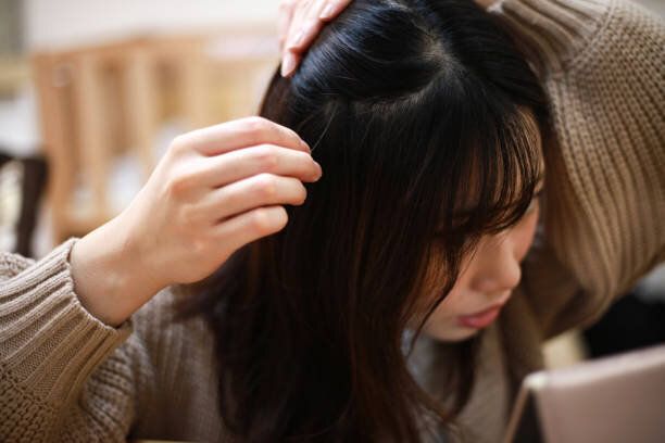 彼女の髪を気にする女性