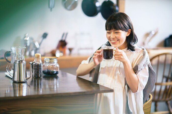 コーヒーを飲みながら飲む若い女性