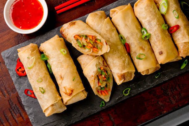卵巻きや春巻き揚げ。繁華のタイ料理レストランの前菜、春巻き、卵ロール。ワントンラッパーから作られ、中国の野菜で満たされ、唐辛子ディップソースを提供しました。